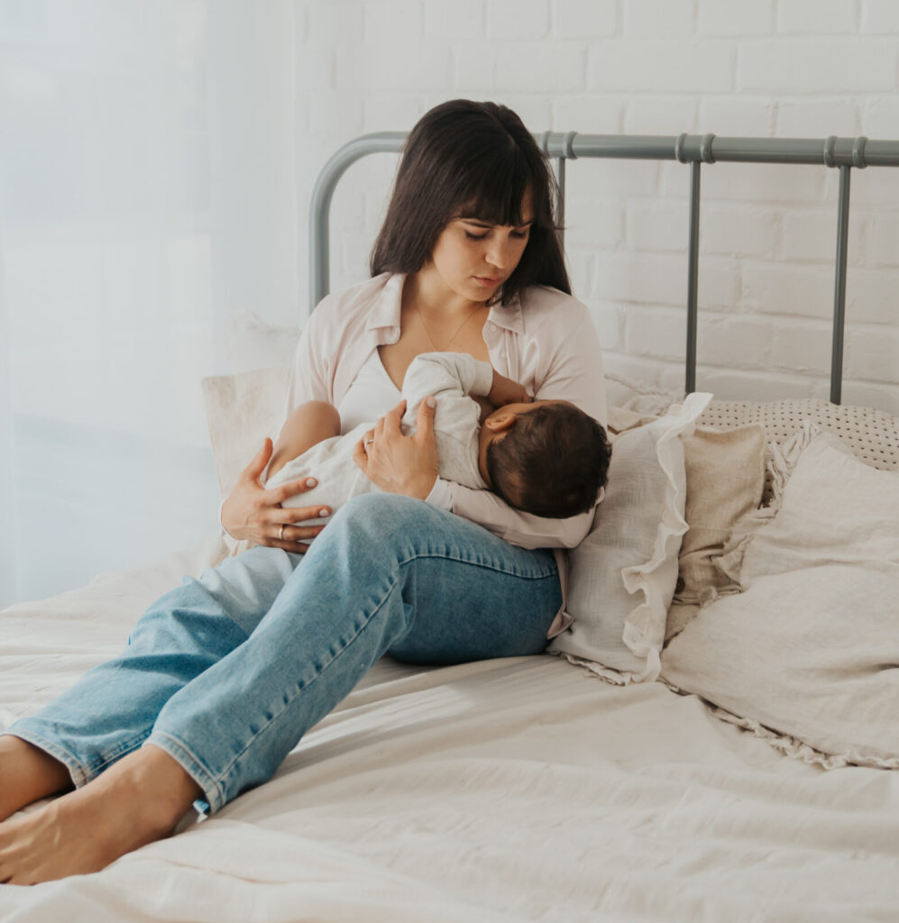 Eine Frau stillt das Neugeborene Kind an der Brust